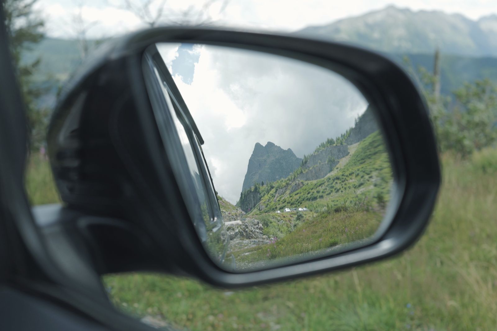 A mountain valley seen in a car's side mirror